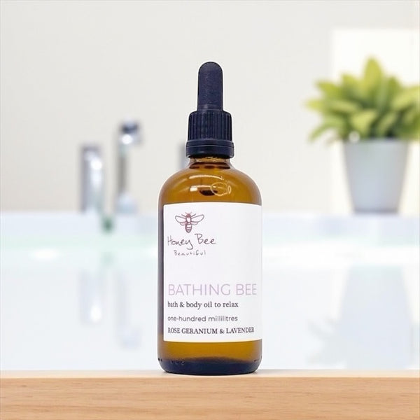 Golden honey-infused bath and body oil in glass bottle deeply moisturising and calming treatment for dry, sensitive or menopausal skin needing relaxation and softness.