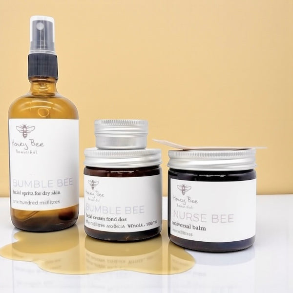 Gift set of raw honey skincare products including face cream, hand cream, and lip balm - especially formulated to nourish, protect, and soothe dry, sensitive menopausal skin, restoring moisture and comfort.