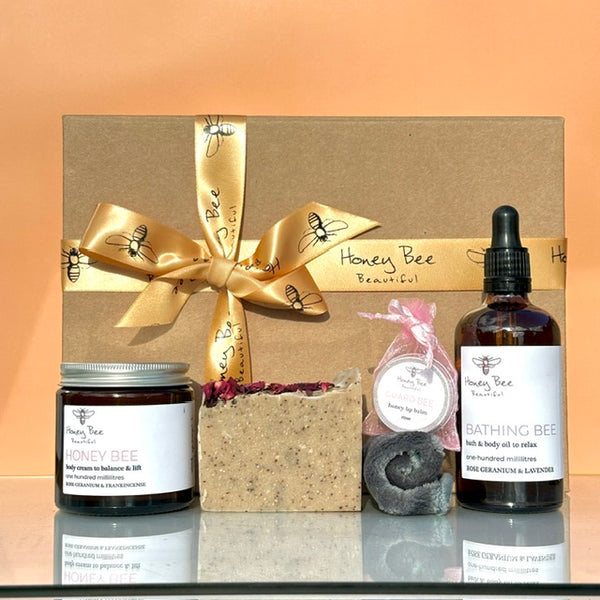 Elegant gift set with rose-infused raw honey skincare products presented in a box designed for dry or menopausal skin that needs calming nourishment and a spa-like ritual.