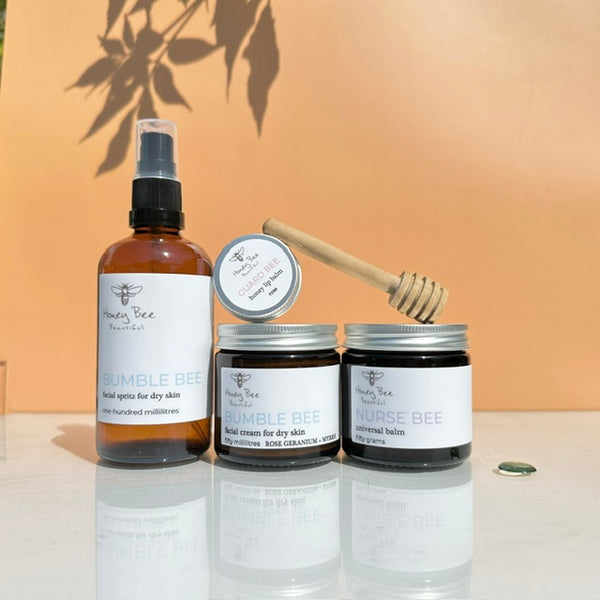 Bundle of raw honey skincare products including moisturising face cream, beeswax balm, hydrating face spritz and honey lip balm - especially formulated to nourish, protect, and soothe dry, sensitive menopausal skin, restoring moisture and comfort.