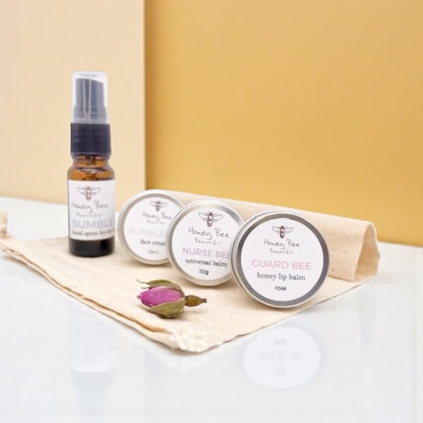 Mini gift set of raw honey skincare products including face cream, hand cream, and lip balm - especially formulated to nourish, protect, and soothe dry, sensitive menopausal skin, restoring moisture and comfort.