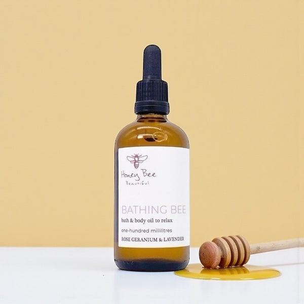 Golden honey-infused bath and body oil in glass bottle deeply moisturising and calming treatment for dry, sensitive or menopausal skin needing relaxation and softness.